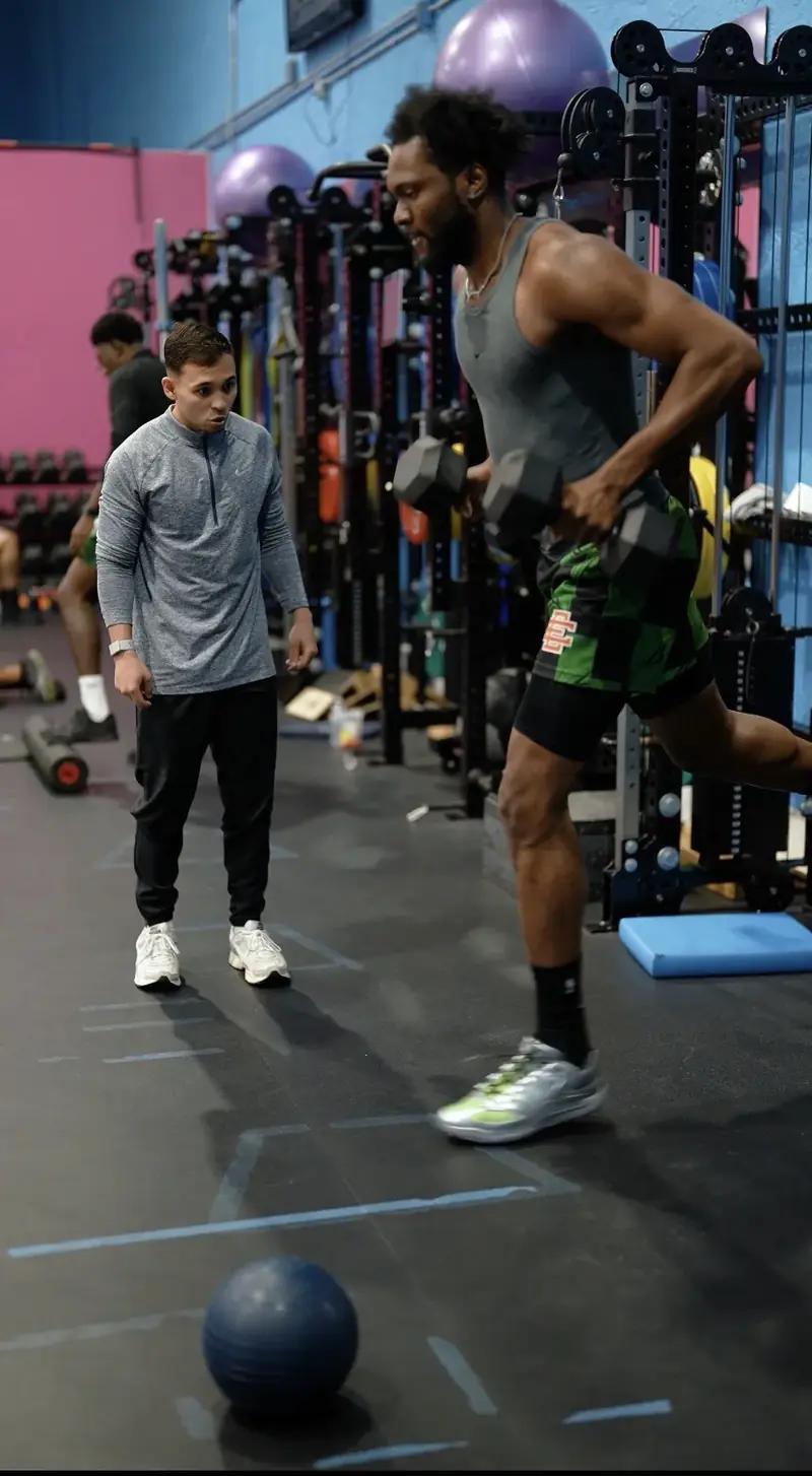 Athlete doing a loaded lunge while Dr. Sierra coaches